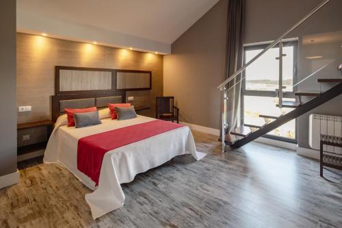 a bedroom with a large bed with a red blanket at A Finca Hotel in Barreiros