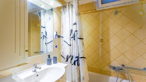 a bathroom with a sink and a shower curtain at Filoxenia in Alepou