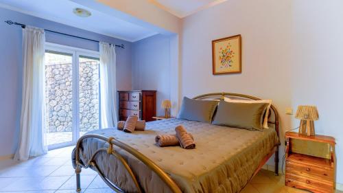 a bedroom with a bed with two shoes on it at Filoxenia in Alepou