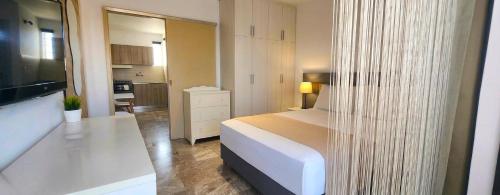 a bedroom with a white bed and a kitchen at Mare Vento in Kiveri