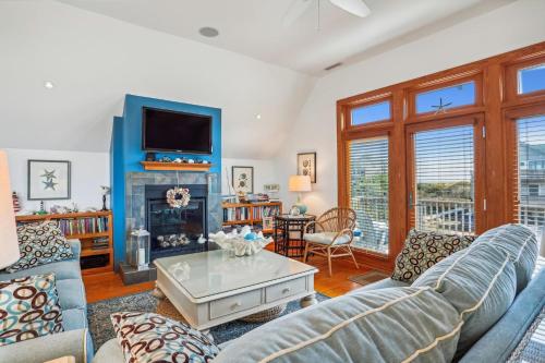 a living room with a couch and a fireplace at 2437 - Sandpiper Station in Duck