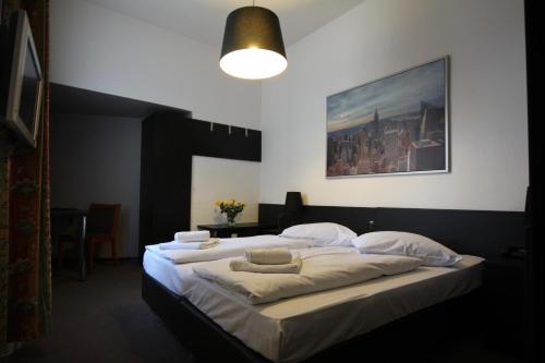 a bedroom with a large bed with white sheets and pillows at Carlton Hotel in Frankfurt/Main