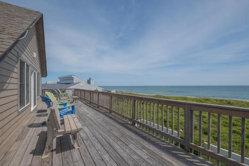 a wooden deck with benches on the side of a house at 2931 - Lighthouse in Duck