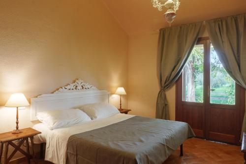 a bedroom with a white bed and a window at Agriturismo Le Pescine in Vada