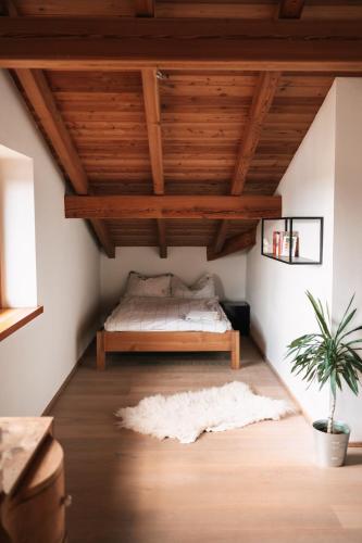 a bedroom with a bed under a wooden ceiling at Scheune am Bio-Bauernhof in Sankt Georgen bei Salzburg