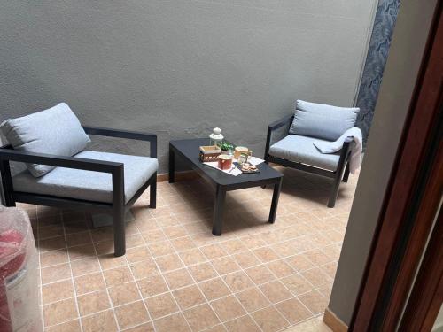a living room with two chairs and a coffee table at NoveQuattro Apartment in Cagliari