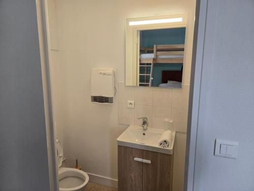 a bathroom with a toilet and a sink and a mirror at Hotel le Saint Germain in Flers