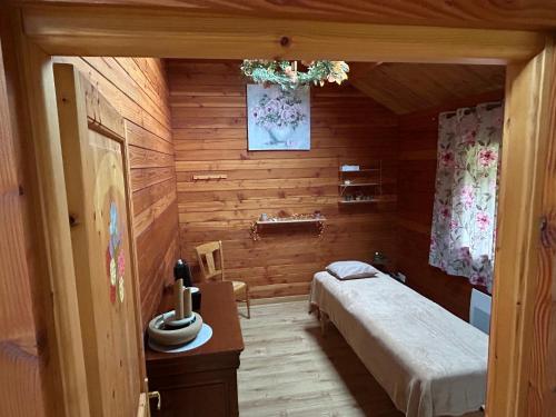 a bedroom with a bed in a wooden room at écrin d'éveil in Campagne-lès-Guînes