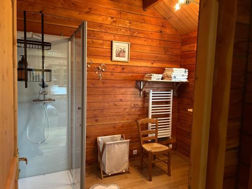 a bathroom with a shower and a wooden wall at écrin d'éveil in Campagne-lès-Guînes