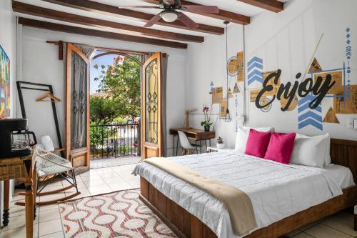 a bedroom with a large bed with pink pillows at Socialtel Granada in Granada