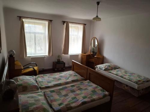 a bedroom with two beds and a mirror and windows at Statek Vranč in Bítov