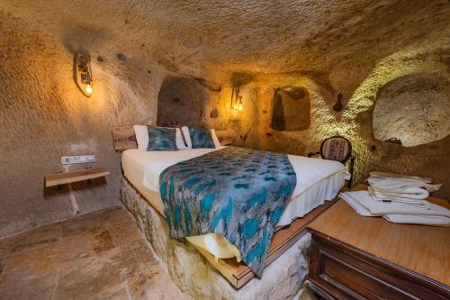 a bedroom with a bed in a cave at Lubberona Cave Cappadocia in Nar