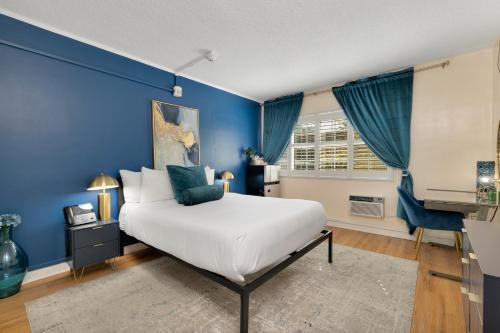 a blue bedroom with a bed and a television at Magic Castle Hotel in Los Angeles