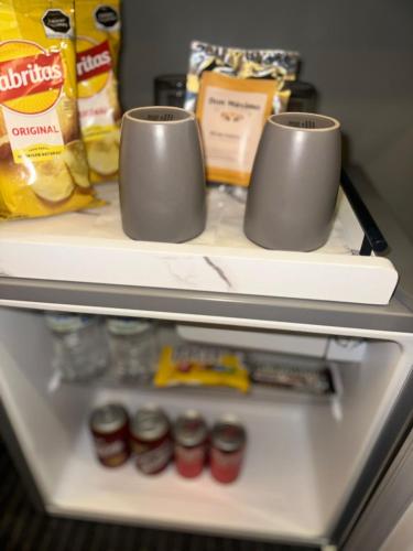 a refrigerator with two cups on top of it at Hotel Boutique Querencia in Tijuana