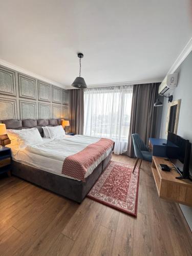 a bedroom with a large bed and a television at Avenue Aparthotel in Sofia