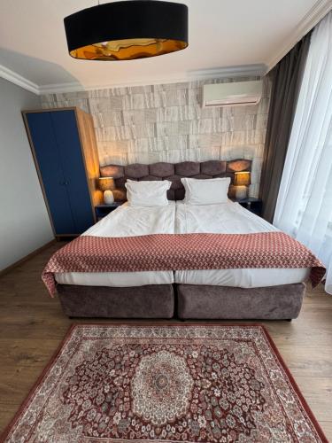 a bedroom with a large bed and a rug at Avenue Aparthotel in Sofia