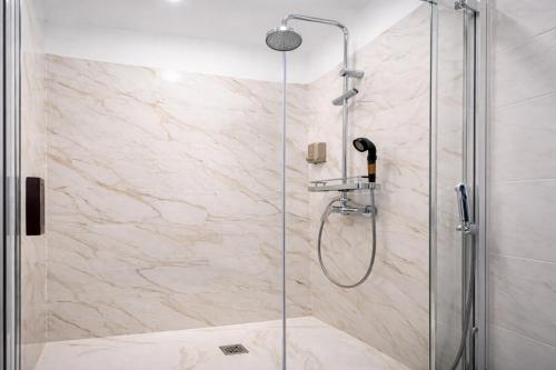 a shower stall with a glass shower door at Happy Sintra Inn Guesthouse & Breakfast in Sintra