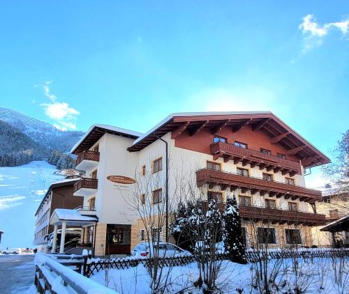 ein großes Gebäude mit Schnee auf dem Boden in der Unterkunft Hotel Sommerer - Hike & Bike in Saalbach, Joker Card inkl in Saalbach-Hinterglemm