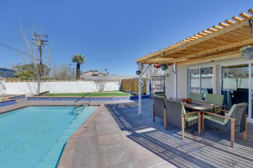 a patio with a table and chairs next to a pool at Elegant Home with Pool Table 3 Mi to Vegas Strip! in Las Vegas