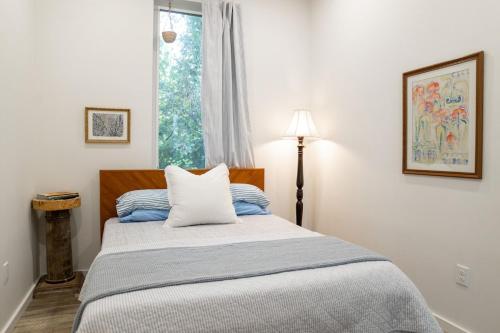 a bedroom with a large bed with a window at Blue Crest Architectural Treehouse Retreat in Ocean Springs