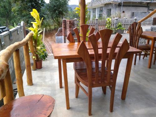 a wooden table and chairs on a patio at Ella Rawana Den Hotel in Ella