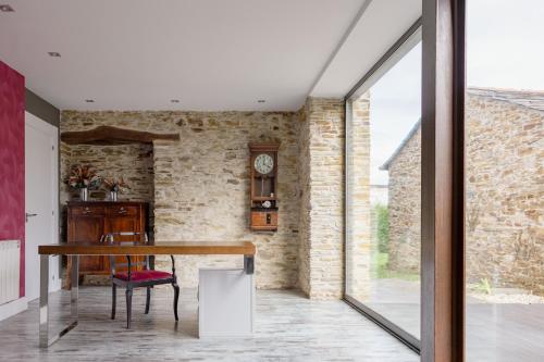 a dining room with a table and a brick wall at A Finca Hotel in Barreiros