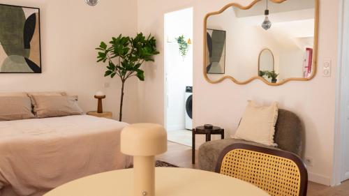 a bedroom with a bed and a chair and a mirror at Le Mercœur, appartement calme en hypercentre in Nantes