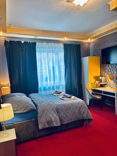 a bedroom with a bed with blue curtains and a desk at Hotel 108 in Glinde bei Hamburg in Hamburg