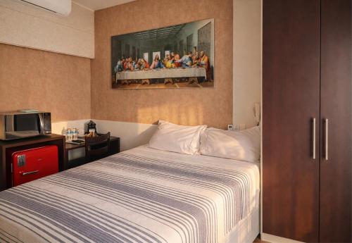a bedroom with a bed and a painting on the wall at O Melhor Apart-Hotel da Cidade! Estacione Grátis in São Caetano do Sul