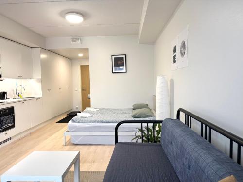 a living room with a bed and a couch at Easy Stay Rooms & Apartments near Airport in Vantaa