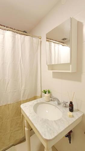 a bathroom with a white sink and a mirror at Apart Alameda in Paraná