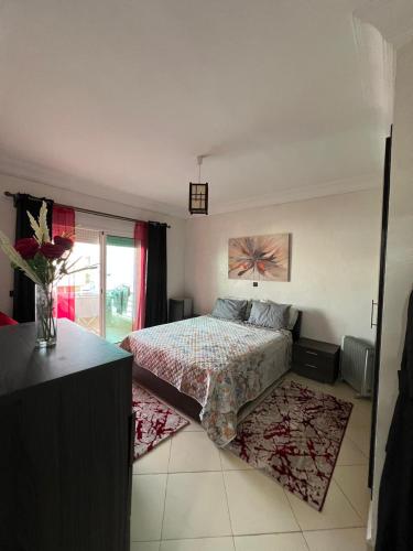 a bedroom with a bed and a vase of flowers at DreamCatcher ocean in Mohammedia