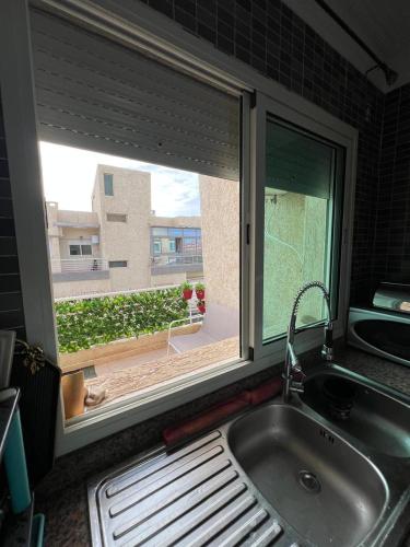 a kitchen window with a sink and a view of a yard at DreamCatcher ocean in Mohammedia