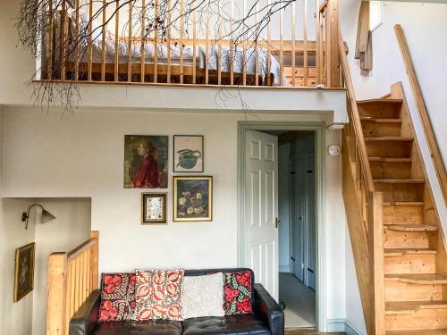 a living room with a couch and a staircase at 11 The Plosh in Keswick