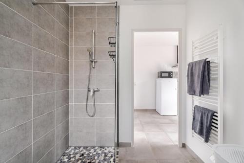 a shower with a glass door in a bathroom at la pause detente, villa climatisée avec jardin et parking privés, à 5 mn de la mer, au calme in Martigues