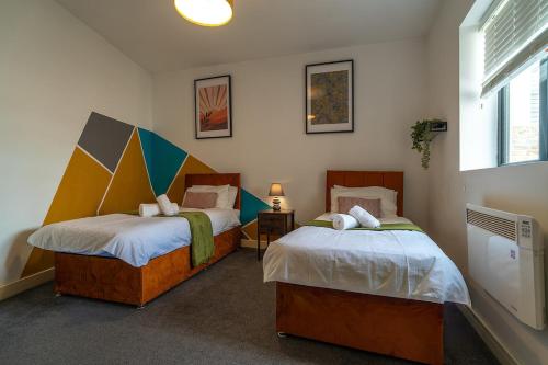 a bedroom with two beds and a window at Vantage Stays in Gloucester