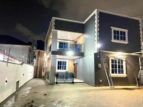 a large house with a staircase in front of it at night at Chameleon Luxury Apartment in Trofwi