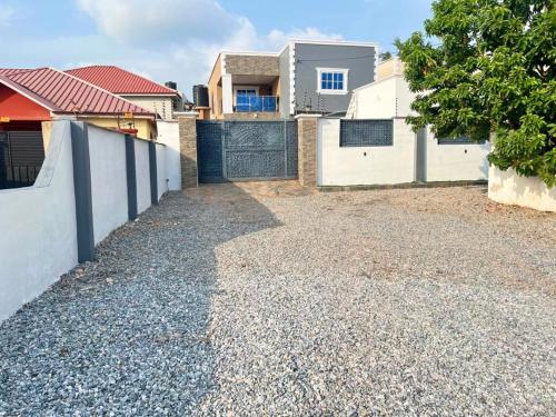 a driveway in front of a house with a fence at Chameleon Luxury Apartment in Trofwi