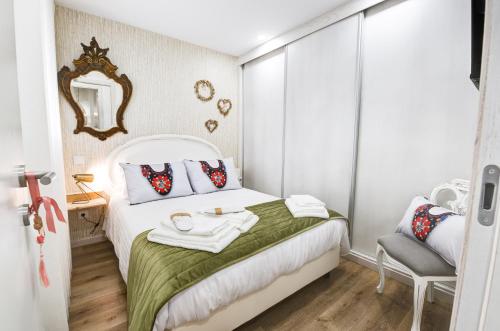 a small bedroom with a white bed and a chair at Lendalima Formosa in Ponte de Lima