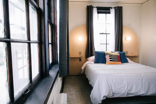 a bedroom with two beds and large windows at The Wilson in Madison