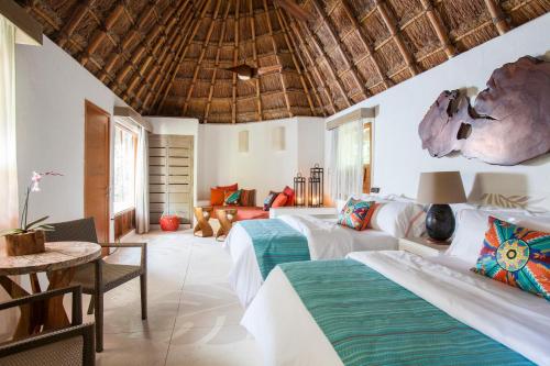 a bedroom with two beds and a living room at Mahekal Beach Front Resort & Spa in Playa del Carmen