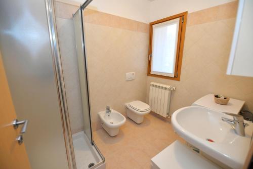 a bathroom with a shower and a toilet and a sink at Eleonora 4A in Temù
