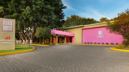 a building with pink and purple walls and a street at Camino Real Guadalajara in Guadalajara