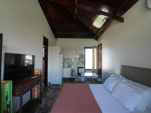 a living room with a bed and a kitchen at Beachfront Studio with Pool Caponga in Cascavel