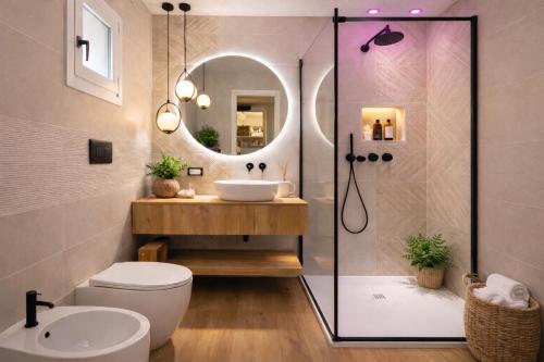 a bathroom with a shower and a toilet and a sink at Japandi Suites Olbia in Olbia