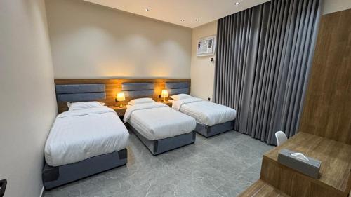 a hotel room with two beds and a television at The Queen Apartment in Jeddah