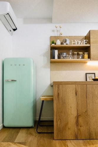 a kitchen with a green refrigerator next to a counter at Japandi Suites Olbia in Olbia
