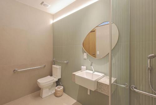 a bathroom with a toilet and a sink and a mirror at Amaraíz Pousada in Maragogi