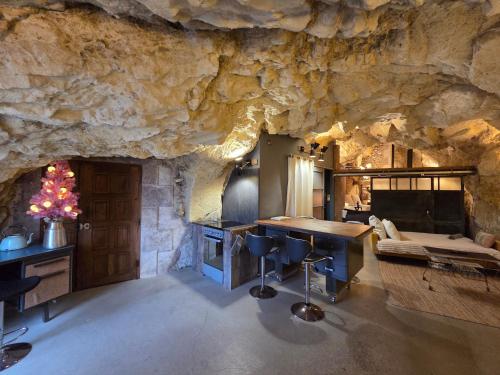 a kitchen in a cave with a stone wall at La Grotte du Moulin in Noyers-sur-Cher