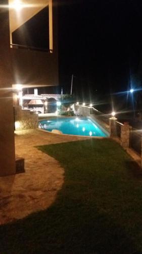 a swimming pool at night with lights at Petrochori ApartHotel in Petrochori
